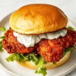 The Baked Nashville Hot Chicken Sandwich I Can’t Stop Making (That Sweet Honey Drizzle Seals the Deal) So here’s the thing—I love a good Nashville hot chicken sandwich, but I don’t love standing over a pot of oil or dealing with a greasy kitchen. This version skips the deep fry and still gives you that spicy, crispy, juicy goodness, all baked in the oven. And then there’s the honey drizzle. Ohhh the honey. It cools things down just enough and makes the whole thing feel kind of irresistible. This is my go-to when I want something spicy, crunchy, and totally satisfying—without the mess. Why You’ll Love This Recipe If you’re into bold flavors and crispy textures but not into deep frying, this one is for you. The chicken bakes up with a crunchy coating (thank you, panko), the spice level is customizable, and the combo of heat and honey is just unbeatable. Plus, the whole sandwich is easy enough for a weeknight but impressive enough for game day or a casual dinner party. Ingredients (Just a Sneak Peek) You’ll be using boneless chicken thighs or breasts, buttermilk, hot sauce, panko breadcrumbs, smoked paprika, cayenne, and honey. The slaw is optional, but I highly recommend it—it adds a nice crunch and coolness. Full list of ingredients is down below in the recipe card. Directions Marinate the Chicken Start by marinating your chicken in a mix of buttermilk and hot sauce. This helps tenderize the meat and gets flavor deep into every bite. Let it sit for at least an hour, or even overnight if you’re planning ahead. Set Up Your Breading Station In one bowl, you’ll have seasoned flour; in another, beaten eggs; and in the last one, panko mixed with a bit of oil, smoked paprika, garlic powder, and cayenne. Dip each piece of chicken through the stations, pressing the breadcrumbs on really well so they stick. Bake Until Crispy Place the breaded chicken on a wire rack over a baking sheet and pop it into a hot oven. Bake until the outside is crispy and golden and the inside is juicy—usually around 25–30 minutes depending on the size of your pieces. Make the Hot Oil Sauce While the chicken bakes, mix up your Nashville-style hot oil. You’ll stir together a bit of neutral oil, cayenne, paprika, brown sugar, and a pinch of garlic powder. As soon as the chicken comes out of the oven, brush this spicy oil all over it. Assemble the Sandwich Toast your buns (this is not optional), then pile on the chicken, a scoop of slaw, and a generous drizzle of honey. Top it with a few pickle slices and the other half of the bun. That’s it. Try not to eat it too fast. Expert Tips and Tricks Use a wire rack when baking—it helps the chicken get crispy all around. And don’t skip the oil in the panko coating; it helps it brown beautifully without needing to fry. Want to turn up the heat? Add more cayenne to the hot oil. Recipe Variations and Possible Substitutions You can use chicken breasts if you prefer white meat, just pound them out a little so they cook evenly. Want to go gluten-free? Use almond flour and GF breadcrumbs. And if you're not into spicy, just scale back the cayenne and add a little smoked paprika instead. Serving and Pairing Suggestions Serve this with sweet potato fries, classic coleslaw, or even a side of mac and cheese. I love it with a crisp pickle and something cold to drink—like sweet tea or a cold beer. For a fun twist, make them slider-sized and serve as a party appetizer. Storage and Reheating Tips Store leftover chicken in an airtight container in the fridge for up to 3 days. To reheat, pop it in the oven or air fryer to bring the crisp back. Don’t microwave unless you’re okay with soft breading—it’ll still taste good, just not crunchy. FAQs Can I make this ahead of time? You can marinate the chicken and prep the slaw ahead, but wait to bake it until you’re ready to eat for the best crunch. How spicy is it? Medium-spicy, but you can totally adjust it by adding or reducing the cayenne in the oil. What kind of honey should I use? Just plain clover honey works great, but hot honey is amazing if you want a little extra kick. Can I make this in the air fryer? Yes! It works beautifully. Just reduce the time slightly and flip halfway through. Conclusion This Baked Nashville Hot Chicken Sandwich with Honey hits all the right notes—crispy, juicy, spicy, sweet, and messy in the best way. It’s perfect when you want something indulgent but a little lighter than the fried version. And once you taste that honey drizzle over spicy chicken? You’ll be making it again and again.